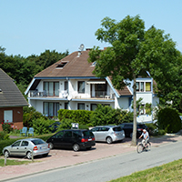 weißes Haus und Parkplätze an der Straße, Blick vom Deich
